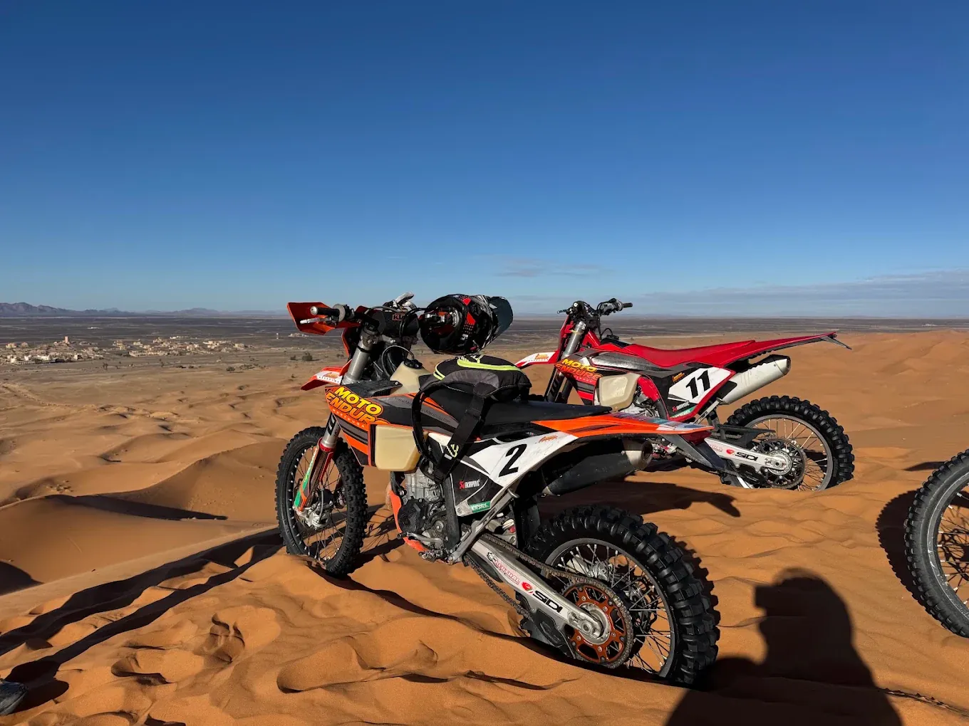 Enduro motorcycle tracing a line across Erg Chebbi sand Enduro motorcycle tracing a line across Erg Chebbi sand