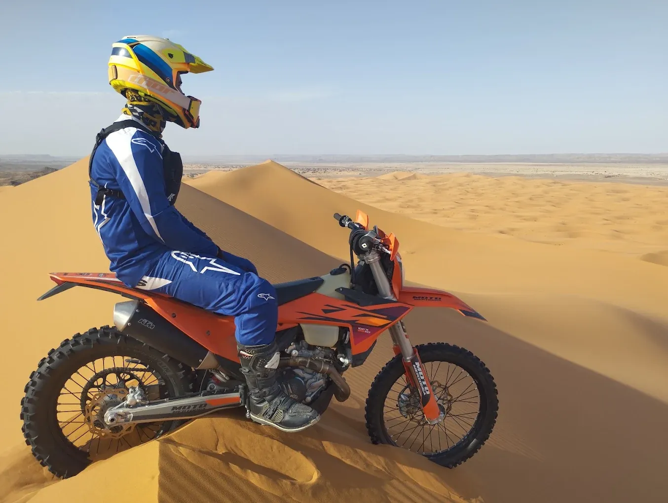 Enduro rider descending a soft Erg Chebbi dune Enduro motorcycle in desert terrain: Merzouga — Tafraout — Merzouga